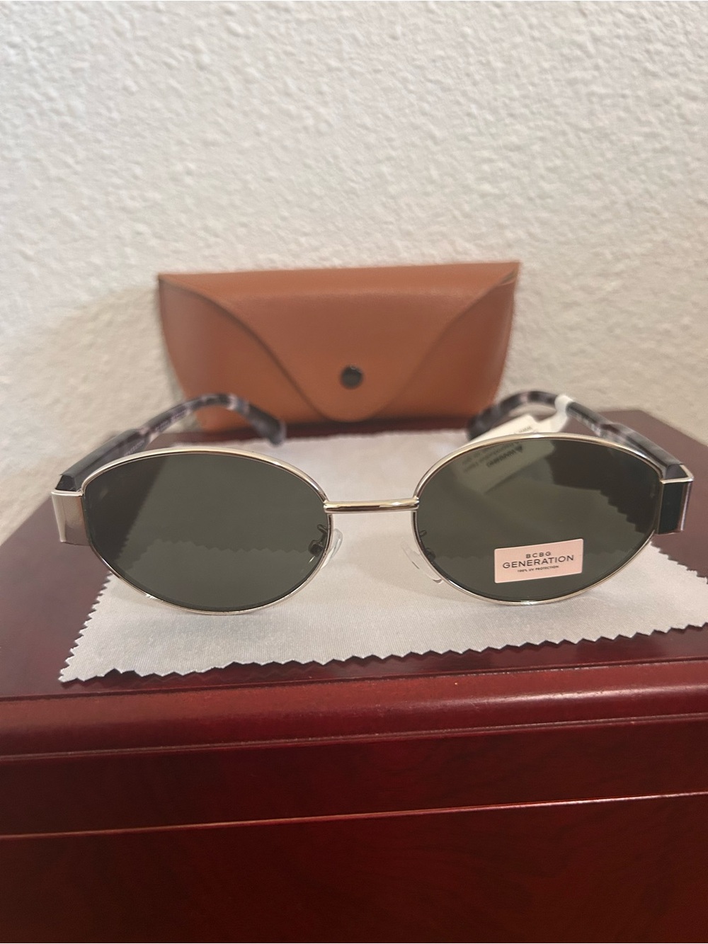 BCBGeneration Silver Frame Oval Sunglasses with Dark Green Lenses